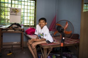 A 25  years old sits on his bed in the morning at the hostel on site at Villa Maria. Marist Solidarity Cambodia seeks to empower young Cambodians with disabilities through education and training, leading to employment and self sufficiency.